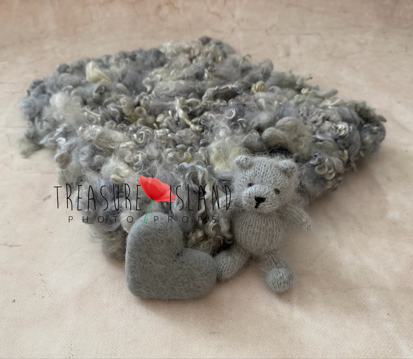 Luxury handmade newborn photography set featuring a curly wool blanket, knitted teddy bear and felted heart in soft grey tones.