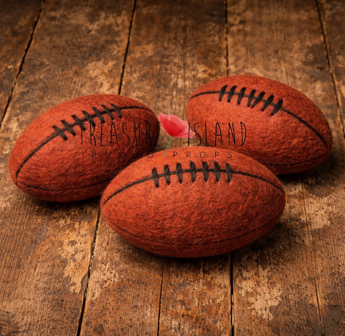 Three orange hand-felted rugby balls with dark lacing in different sizes for newborn and sitter photography