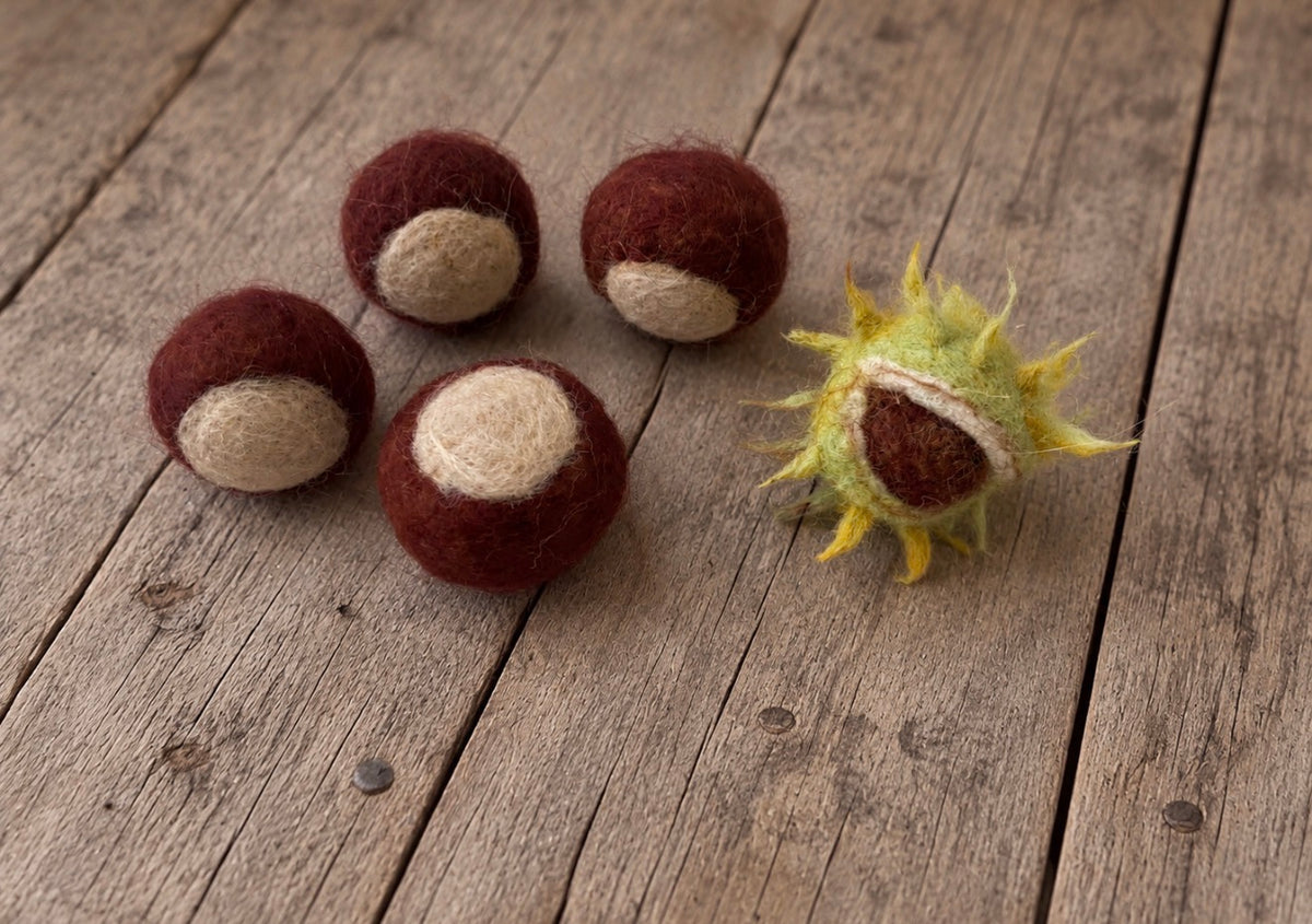 Handmade felted chestnut set arranged as woodland styling props for autumn photography