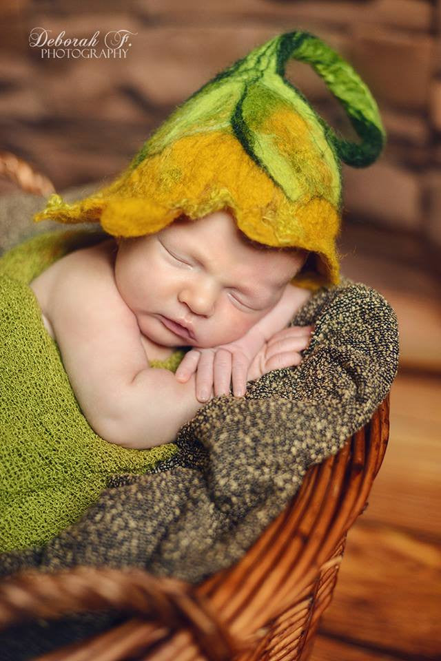 Handmade felted woodland hat in a warm green and mustard newborn photography setup
