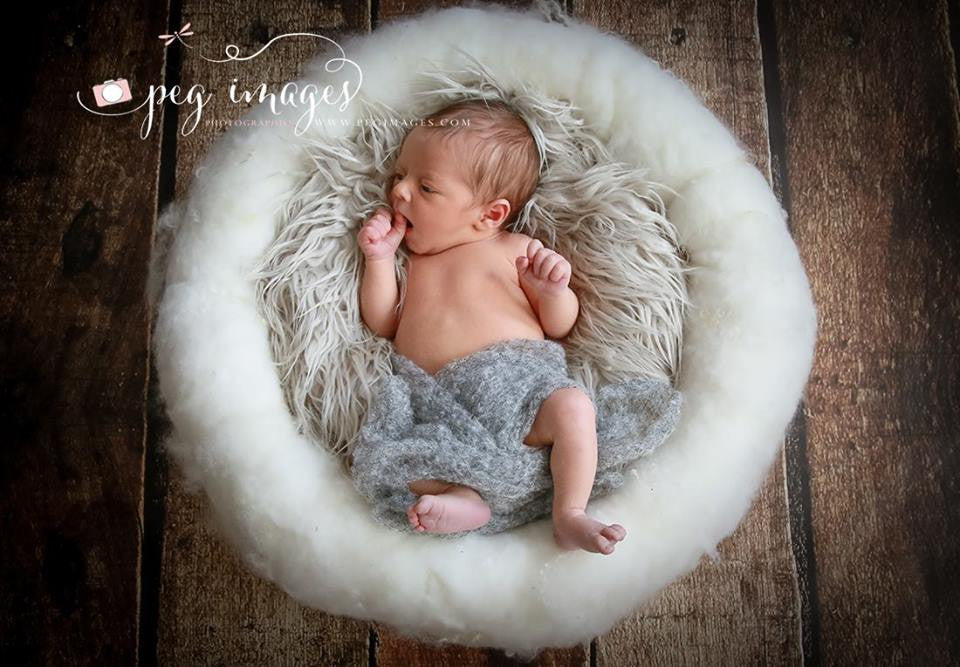 Newborn posed inside a soft white PURE CLOUD nest in a neutral photography setup