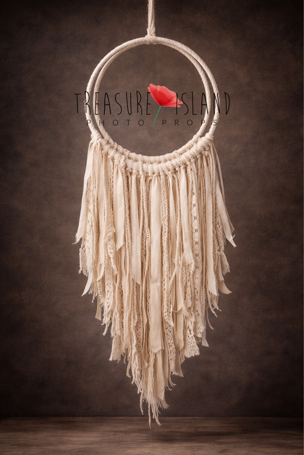 Handmade boho macrame dream catcher with cascading cotton cords, ribbons and lace details on dark brown background

