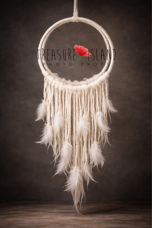 Handmade wool-wrapped dream catcher photography prop with felted hanging strands and soft marabou feathers, suspended against a dark textured backdrop – fine art newborn studio prop.