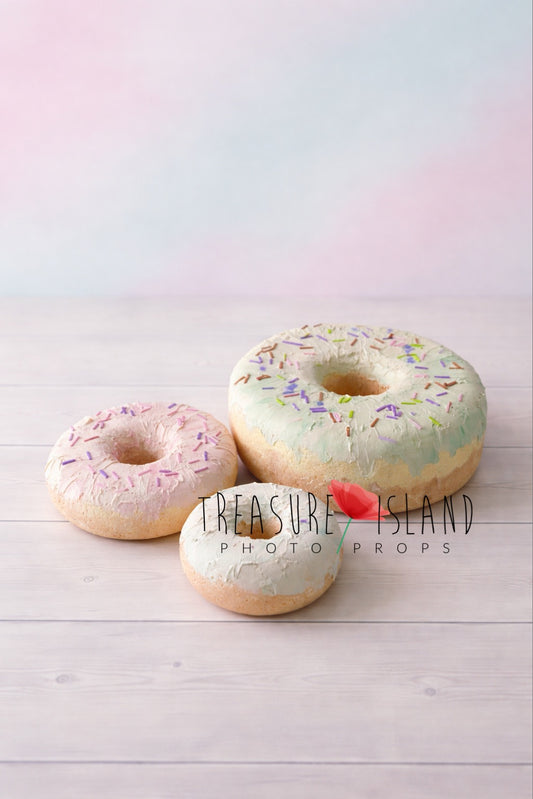Oversized faux doughnut prop set for cake smash photography, hand-painted pastel icing with colorful sprinkles on studio background
