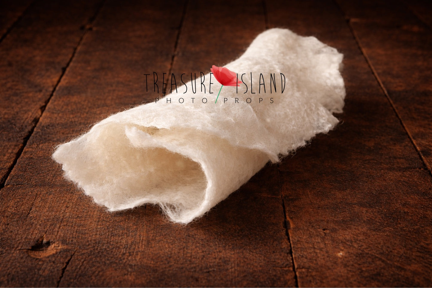 Hand-felted newborn photography wrap in natural white, rolled wool fabric photo prop on dark rustic wooden floor, soft organic texture