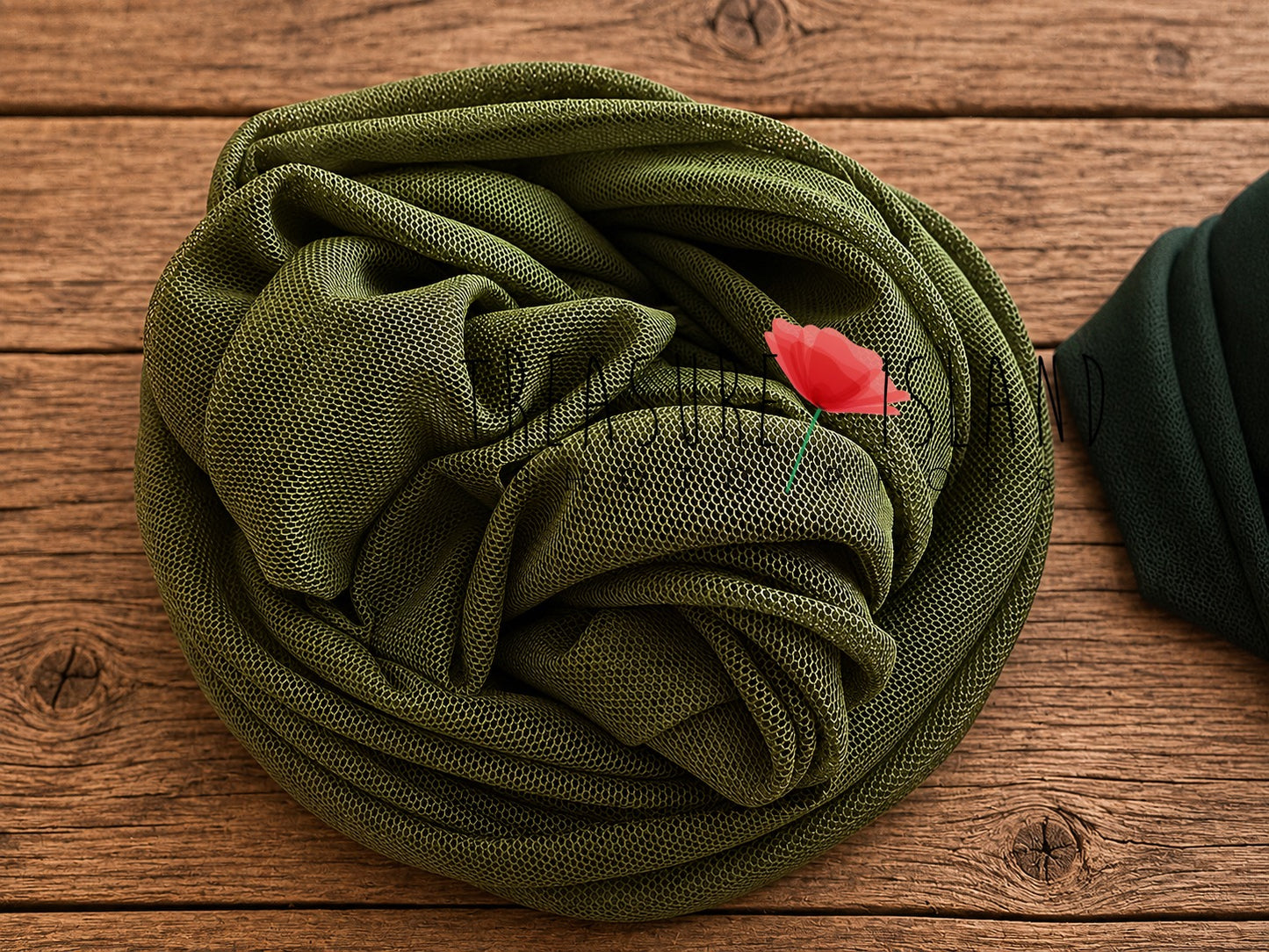 Olive green newborn photography wrap with delicate mesh texture styled on rustic wooden floor – extra stretch fabric for newborn posing and fine art newborn photography