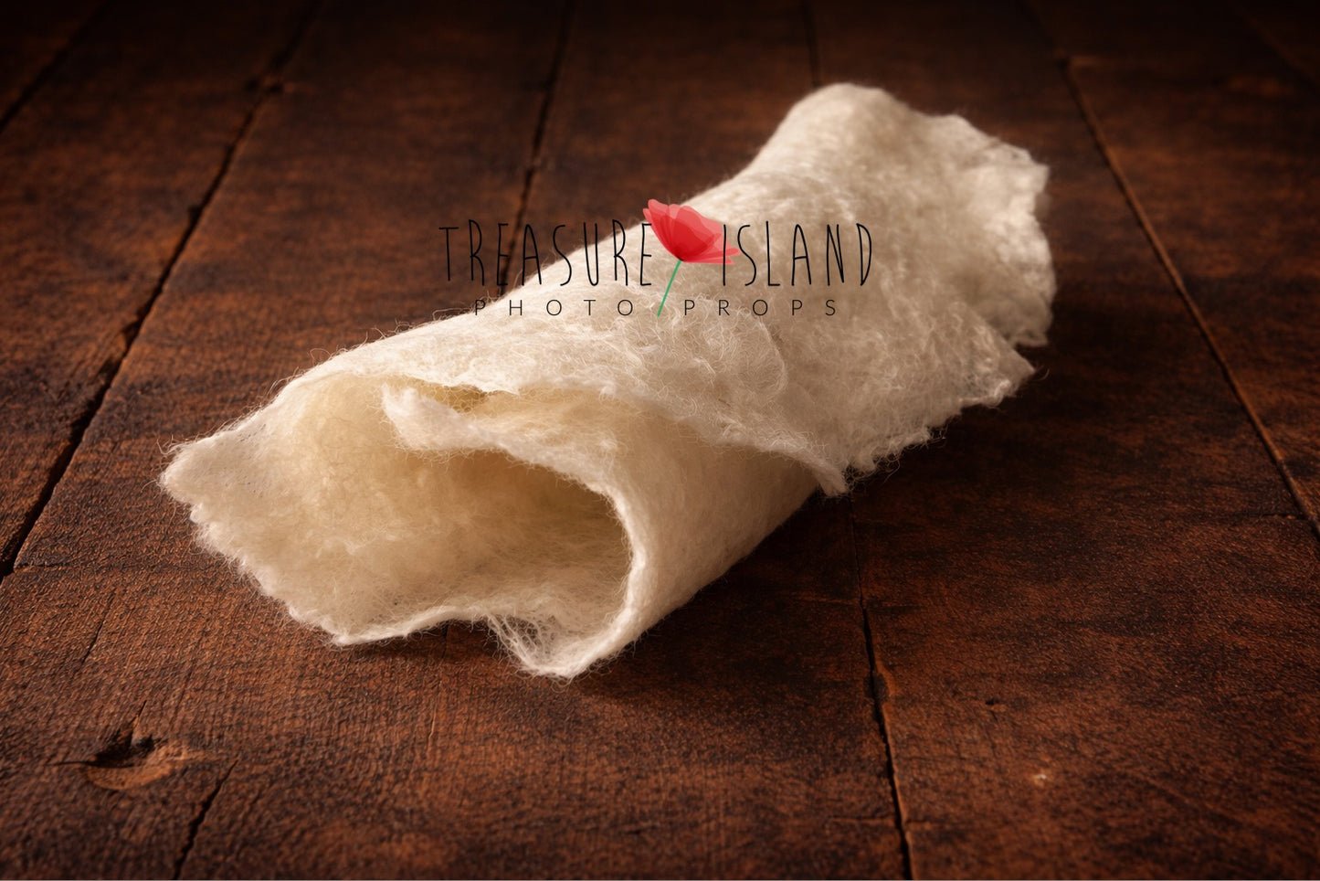 Hand-felted newborn photography wrap in cream , rolled wool fabric photo prop on dark rustic wooden floor, soft organic texture