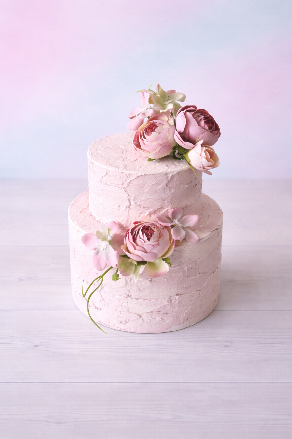 Romantic floral faux cake prop for cake smash photography, hand-painted textured finish with pink flowers, studio background