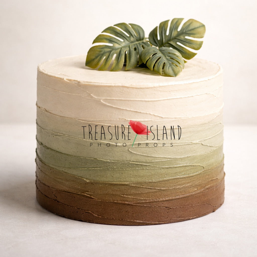 Styrofoam cake from the Safari Collection – Safari Essence Edition. Designed for cake smash photography with a soft ombre transition from chocolate beige to olive sage and warm cream tones. Finished with horizontal textured structure and decorated with three matte monstera leaves for a minimalist safari look.