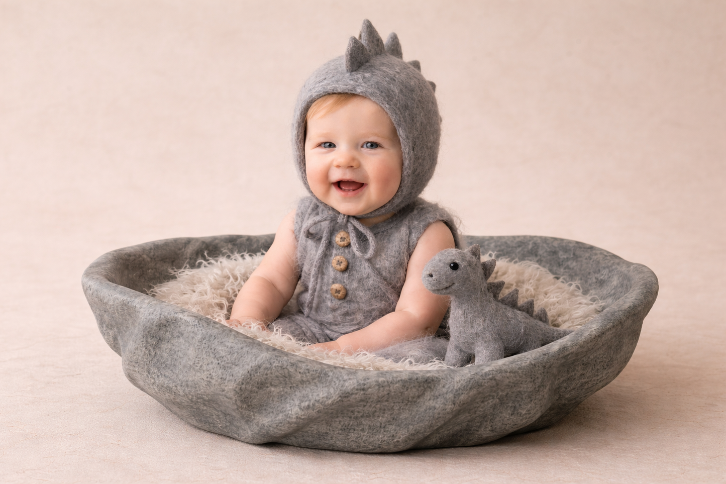 “Luxury newborn photography prop – textured grey handcrafted styrofoam bowl with hand-felted dinosaur bonnet, wool romper and matching felt dinosaur toy.