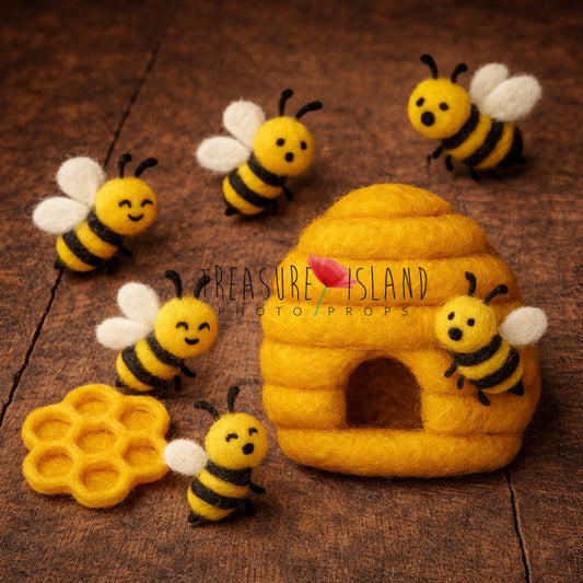 Handmade felt bee set with yellow beehive, honeycomb and small wool bees arranged on a rustic dark wooden background, newborn photography prop styling