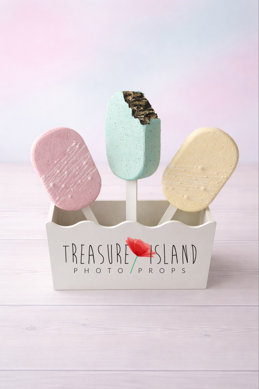 Hand-painted faux ice cream popsicle props for cake smash photography, pastel colors on studio background
