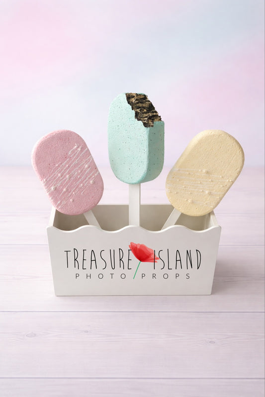 Hand-painted faux ice cream popsicle props for cake smash photography, pastel colors on studio background
