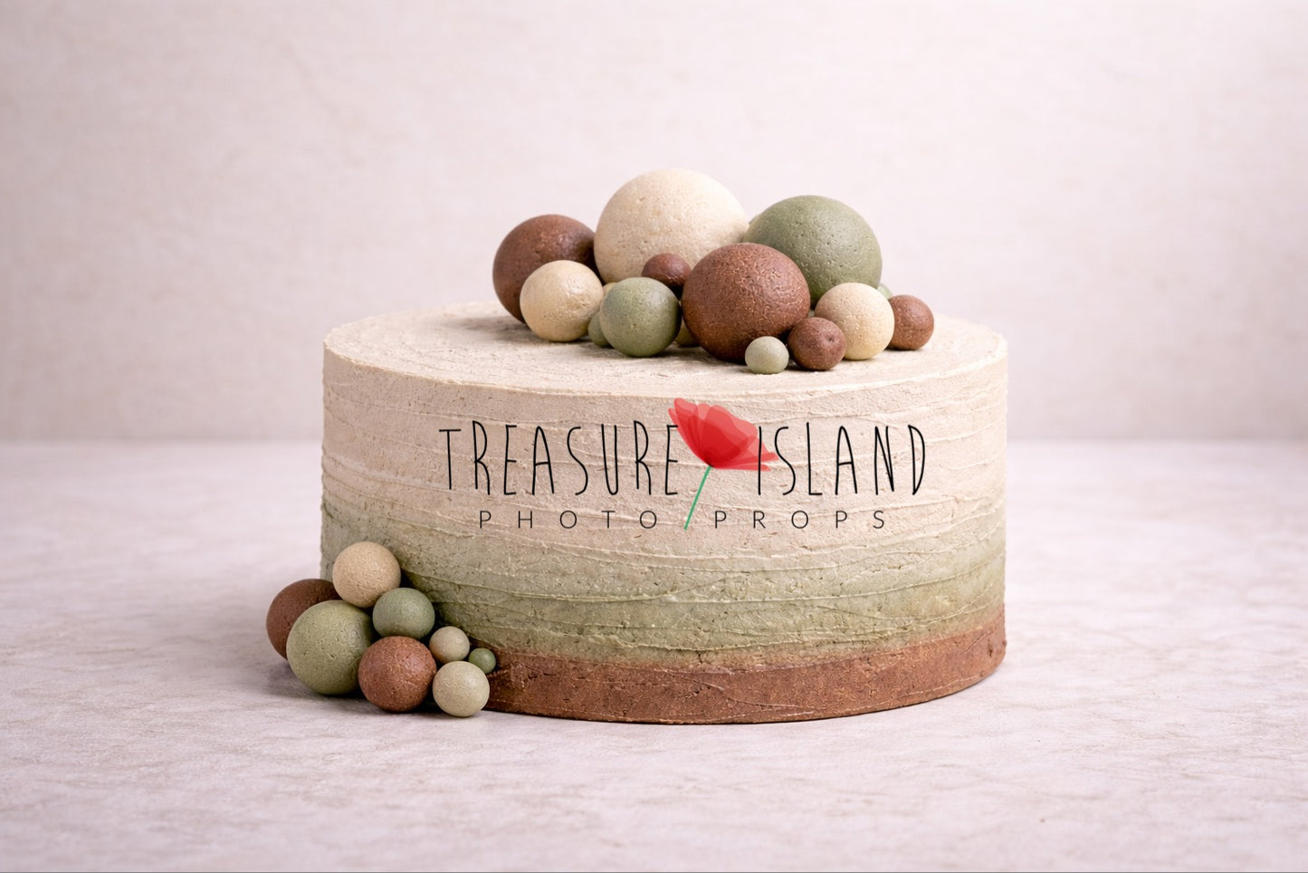 Styrofoam cake for cake smash sessions from the Safari Collection, featuring a soft ombre finish in chocolate brown, olive sage and warm cream tones with horizontal textured structure. Decorated with asymmetrical styrofoam spheres in earthy shades placed on top and along the side for a modern safari look.