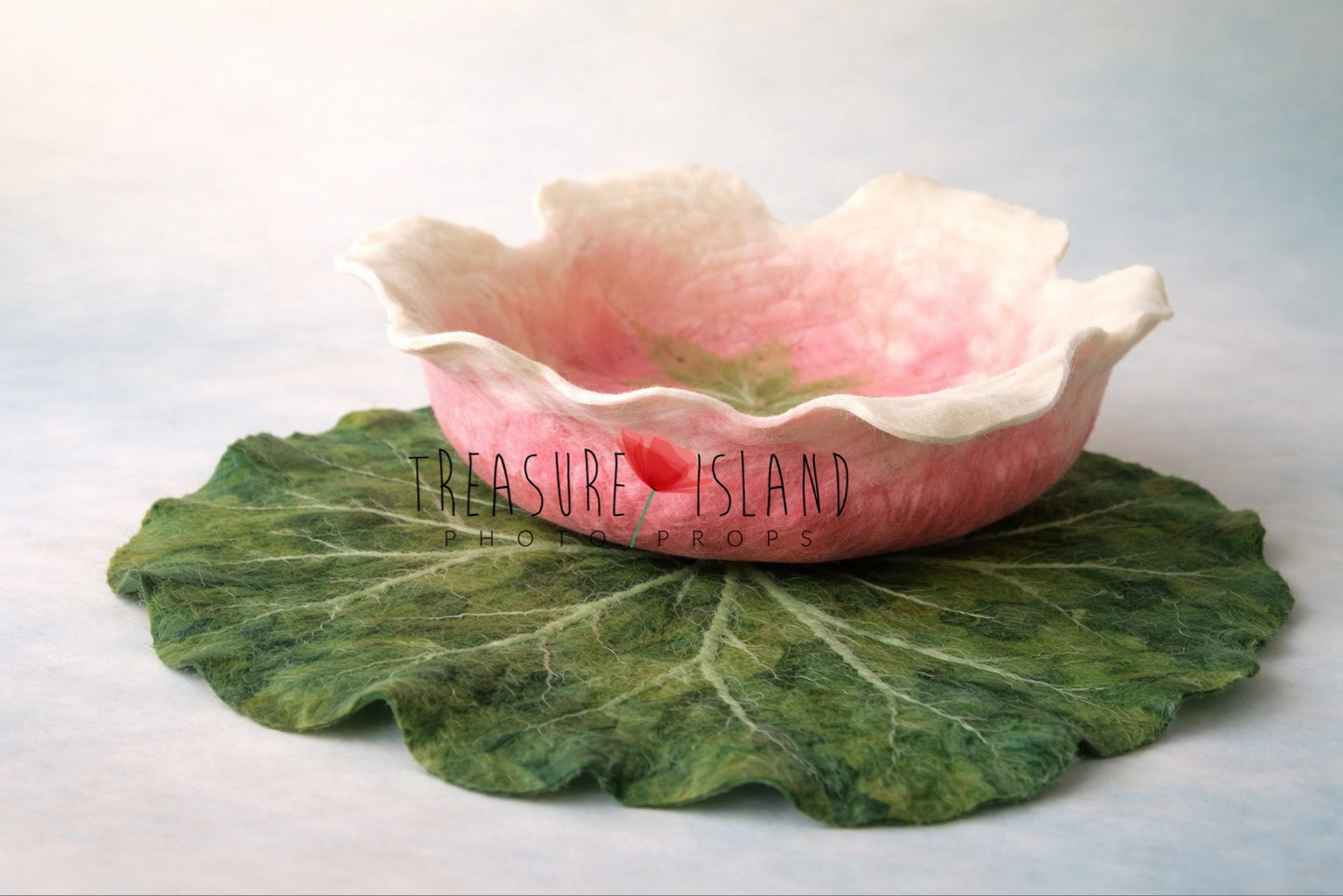 Handmade blush and cream felted bowl placed on a large green water lily leaf, unique newborn photography prop
