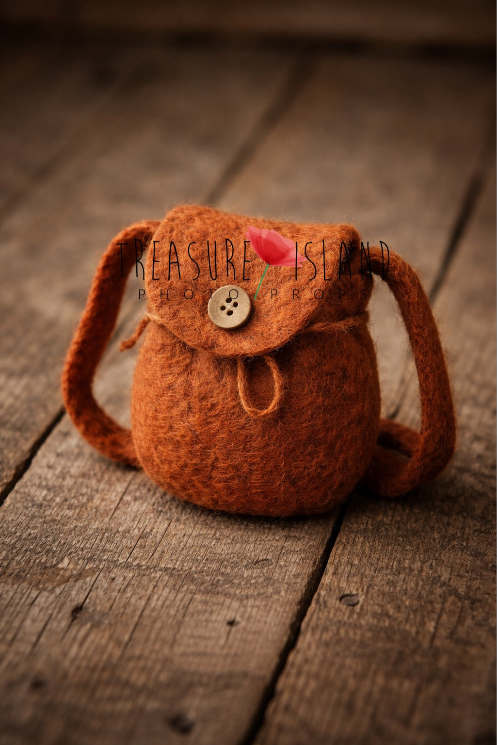 Luxury handmade needle-felted miniature backpack in rich rust tone, 14 cm newborn photography prop styled on aged wooden floor.