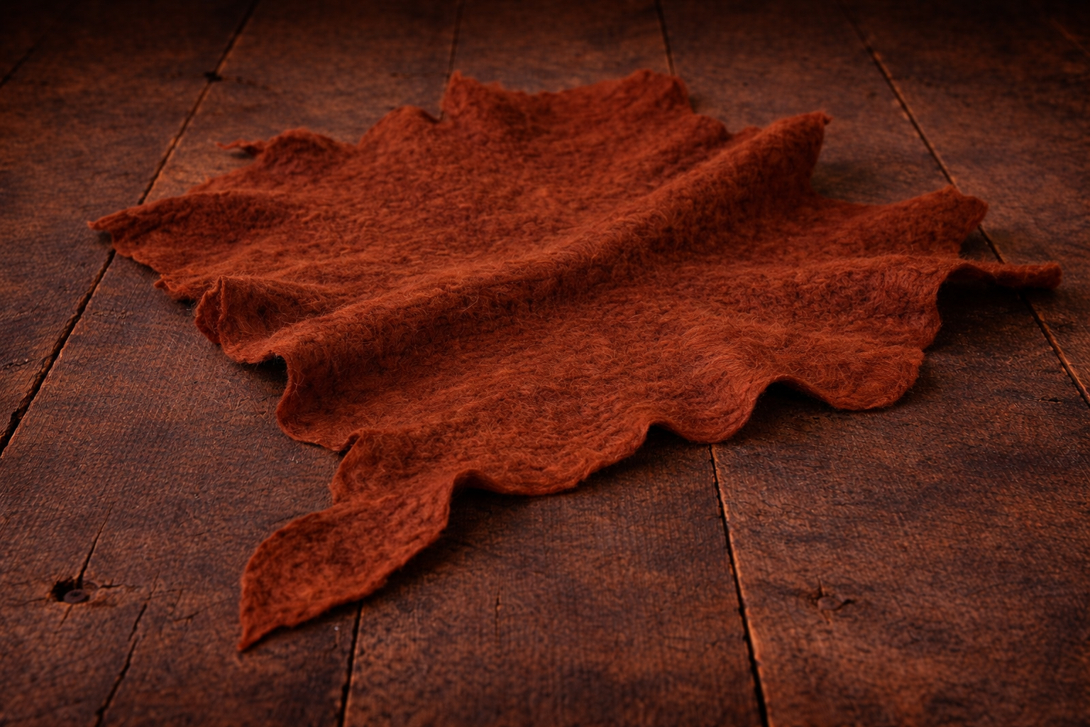 Rust hand-felted irregular wool blanket with organic edges