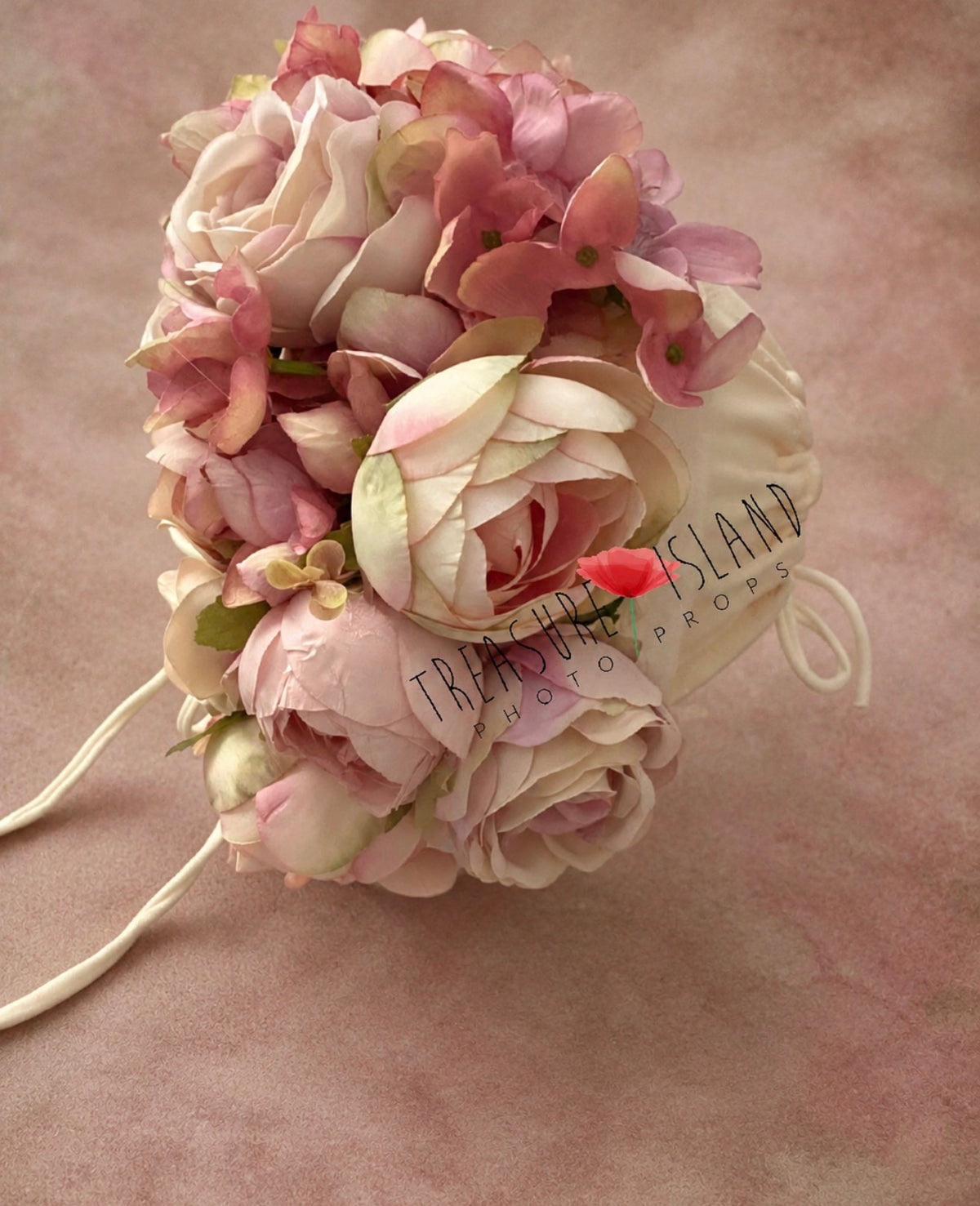 Detailed view of blush pink and ivory flowers arranged around a handmade photography bonnet