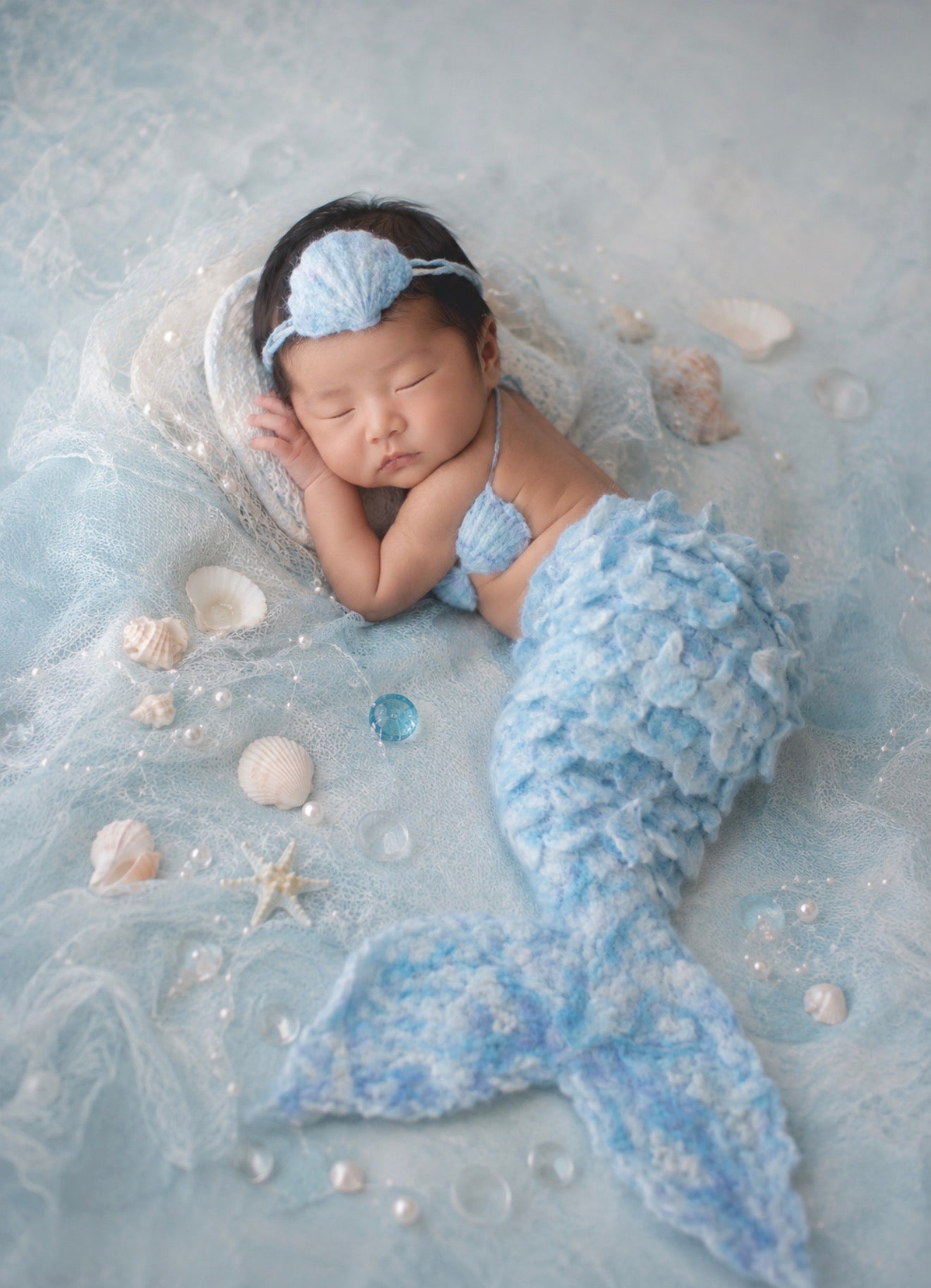 Newborn wearing Ice Pearl handmade felted mermaid tail, shell top and headband