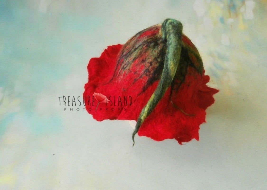 Back detail of handmade felted poppy bonnet with red wool petals and sculptural green stem