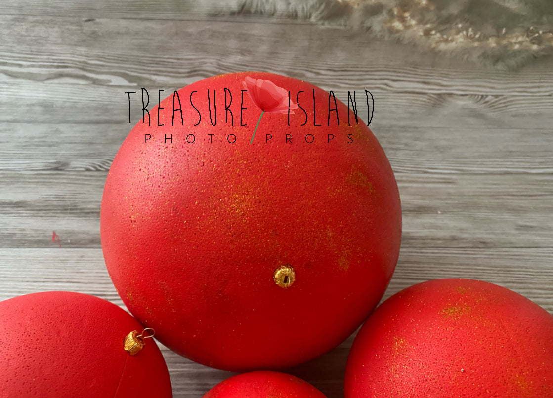 Large red Christmas bauble with gold detail for holiday photography setups
