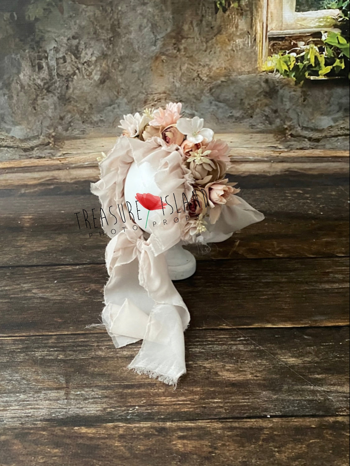 Side view of handmade floral newborn photography bonnet with layered artificial flowers and flowing fabric ties