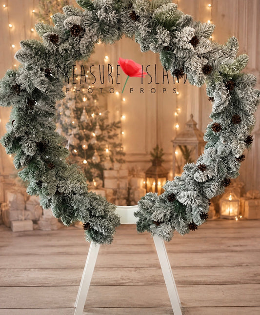 Luxury snowy Christmas garland with frosted evergreen branches and pinecones on a circular photography frame
