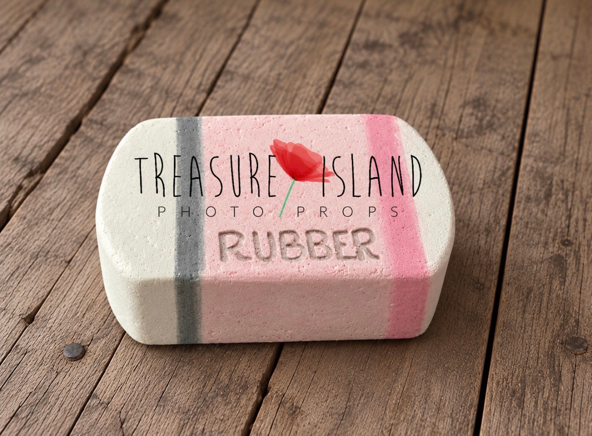 Handmade miniature-style pink Styrofoam pencil with a beige sharpened tip, grey point and rounded pink eraser end, standing upright on wooden flooring