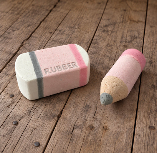 Handmade pink Styrofoam pencil and matching eraser with embossed RUBBER lettering, displayed together on a rustic wooden background