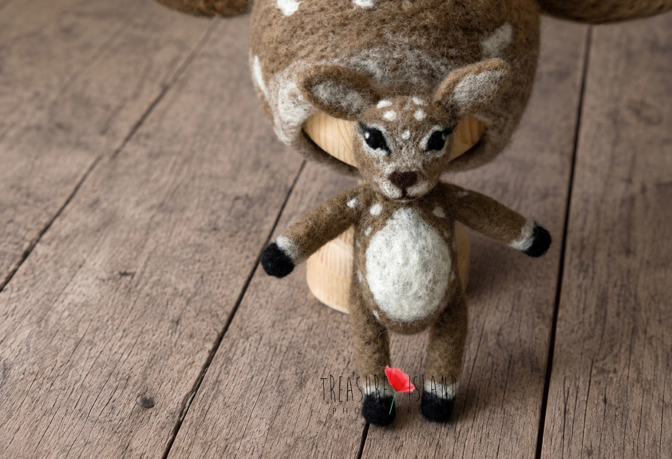 Close-up of miniature hand-felted deer toy with white spotted markings for newborn photography styling