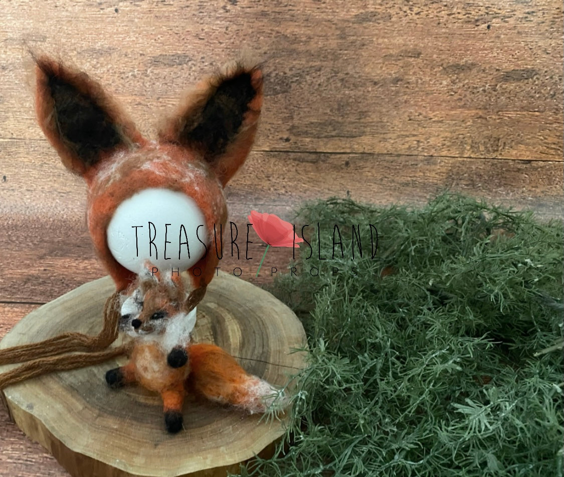 Stuffed fox toy on a wooden platform with a natural background
