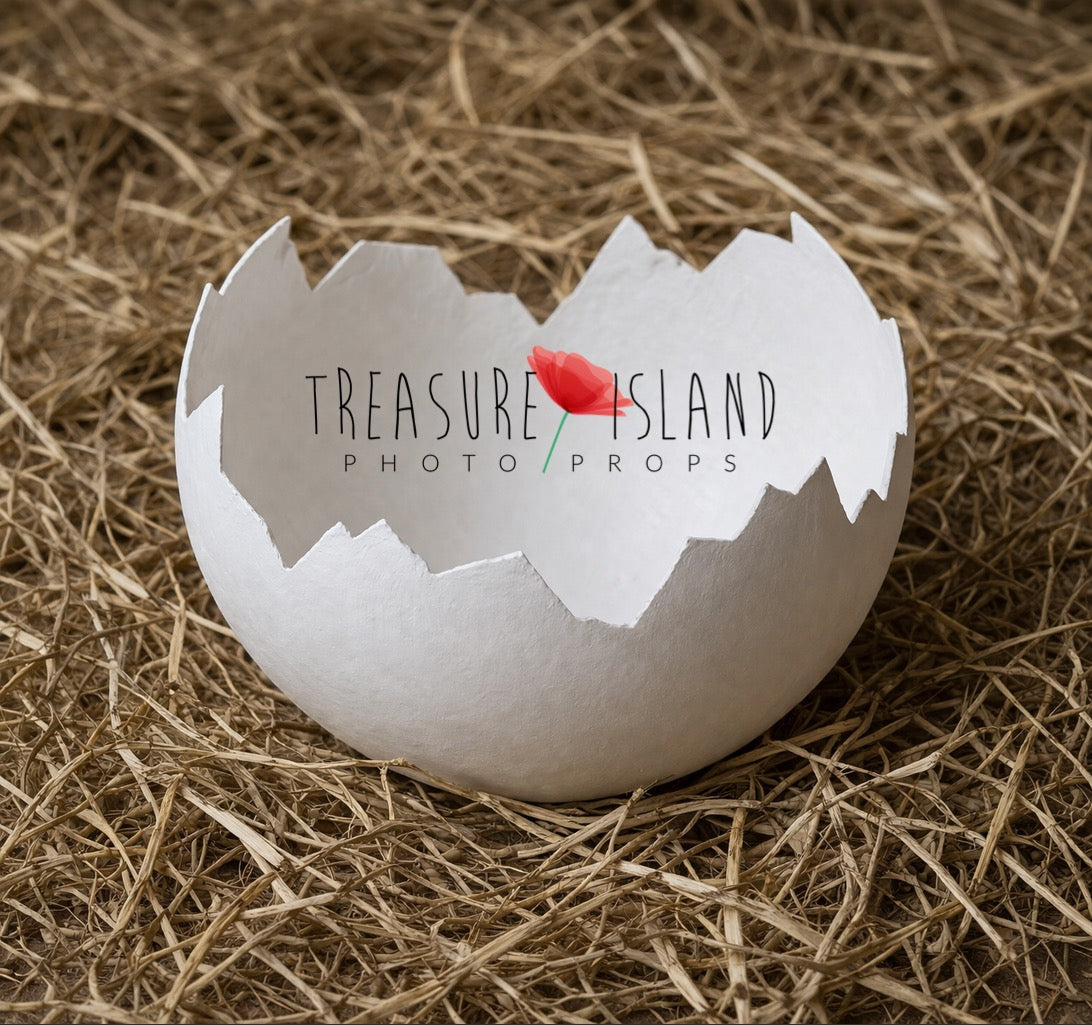 Handmade white plaster egg shell photography prop styled on rustic straw