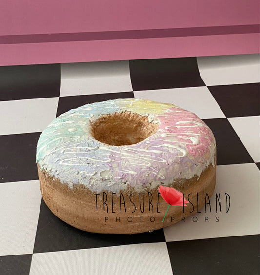 Handmade styrofoam donut photography prop with pastel rainbow glaze and white drizzle