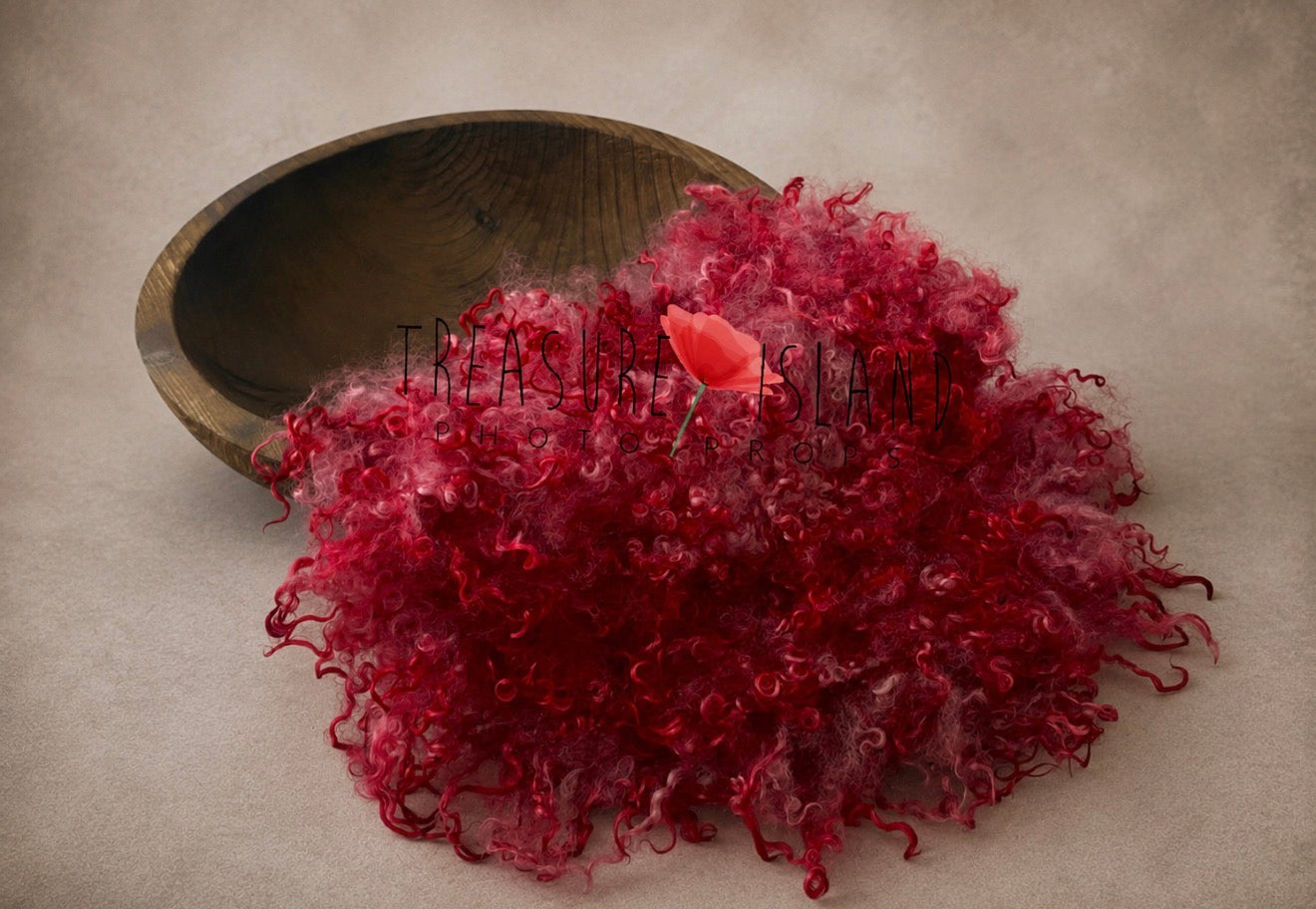Red curly wool blanket with natural sheep locks styled in a newborn photography bow