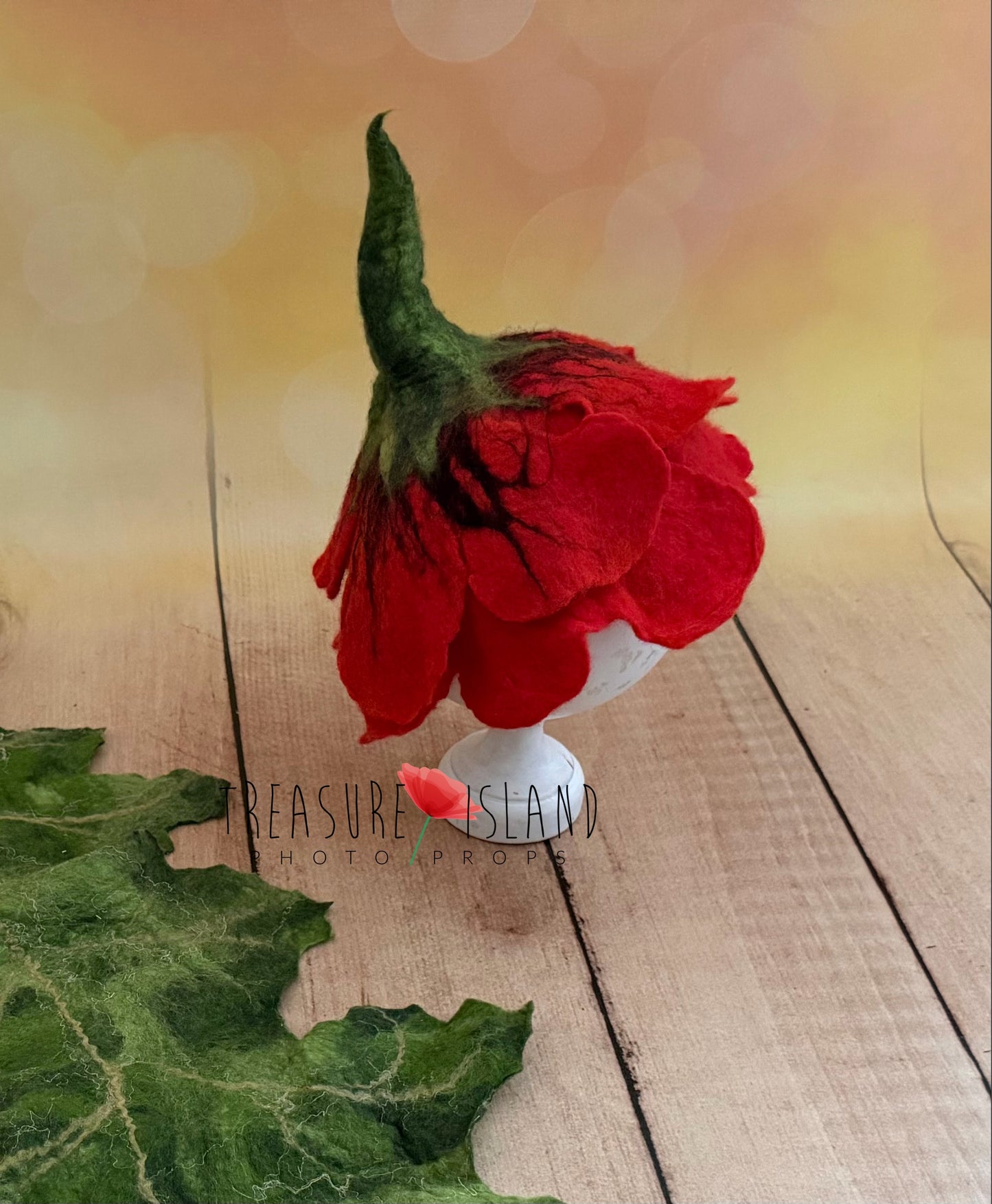 Red hand-felted poppy bonnet with sculptural petals and coordinating green felted leaf