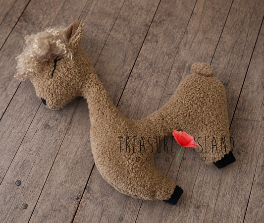Warm beige alpaca newborn posing pillow with natural curls and long curved neck