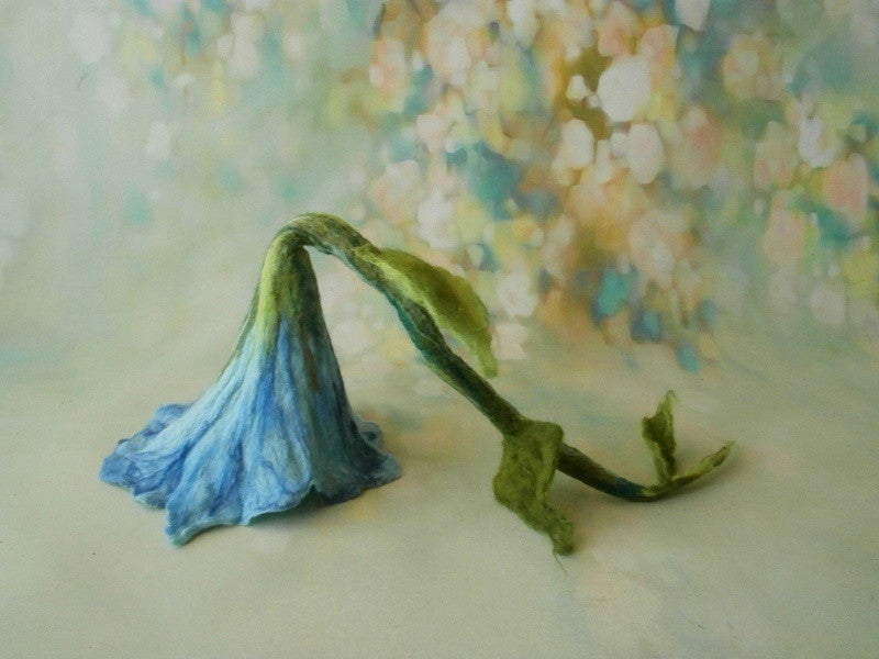 Blue hand-felted flower hat with an elongated green stalk and leaves for newborn photography