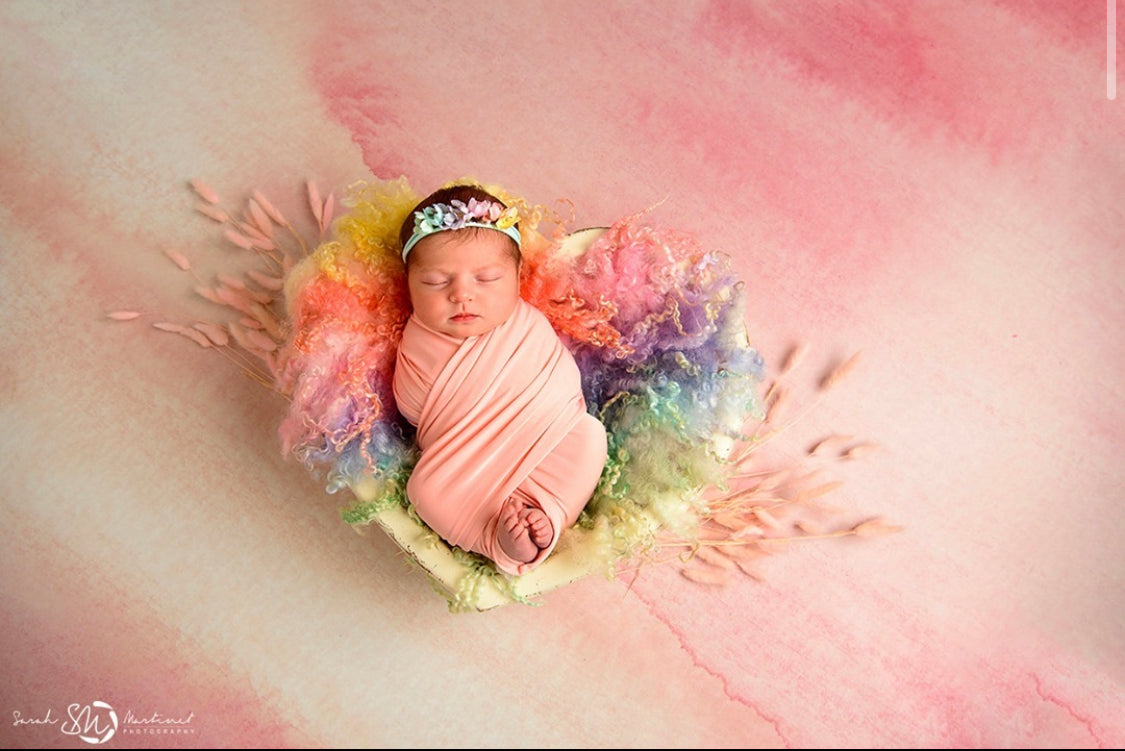 Classic rainbow heart-shaped wool blanket with natural sheep curls styled for newborn photography