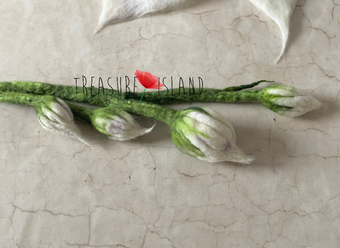Detail of flexible green felted stem with handmade white hanging flowers