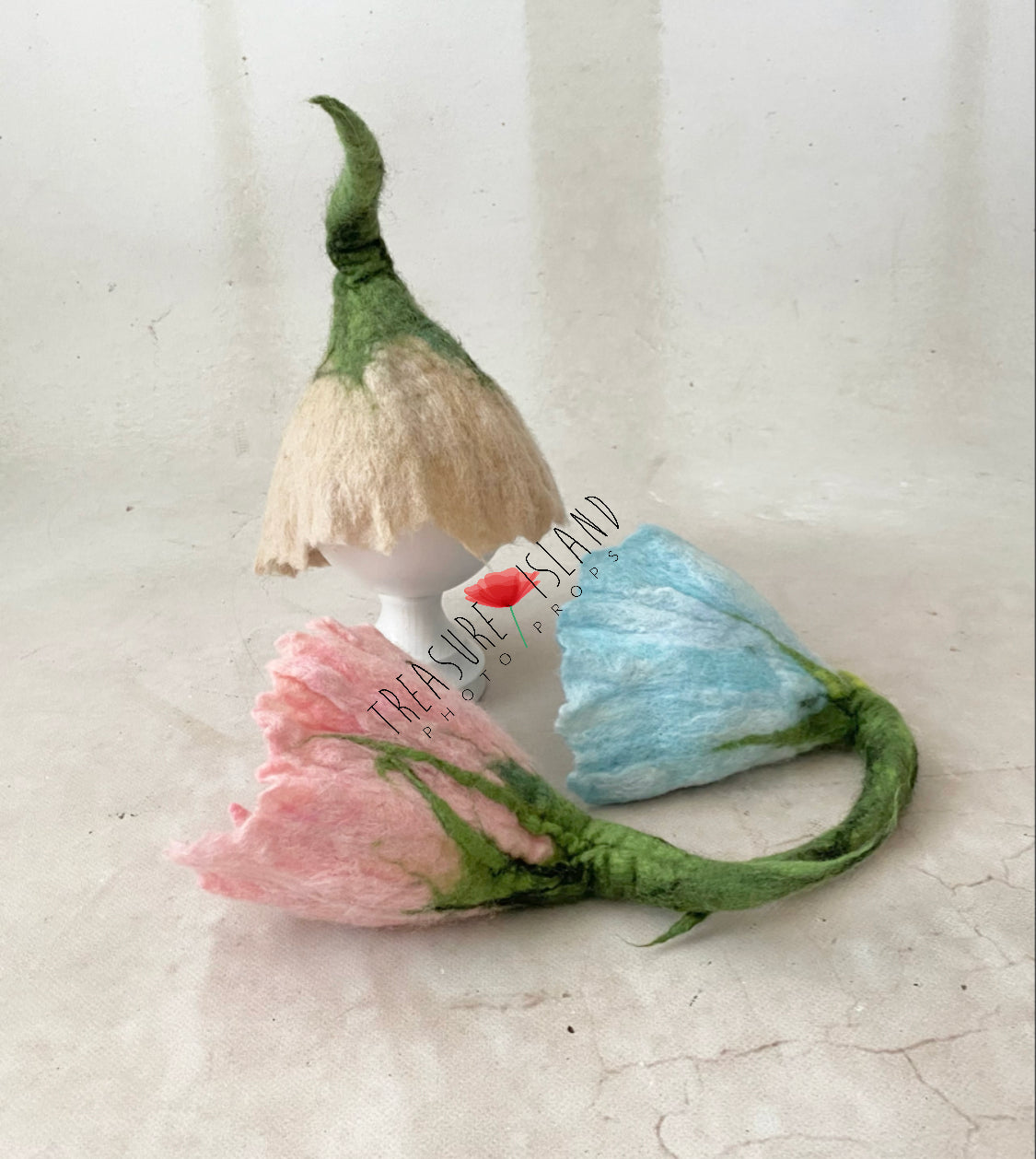 Handmade felted flower hats in blush pink, ivory and light blue with green stems