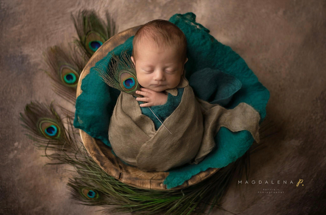 Thin felted wool wrap layered around newborn during photography session