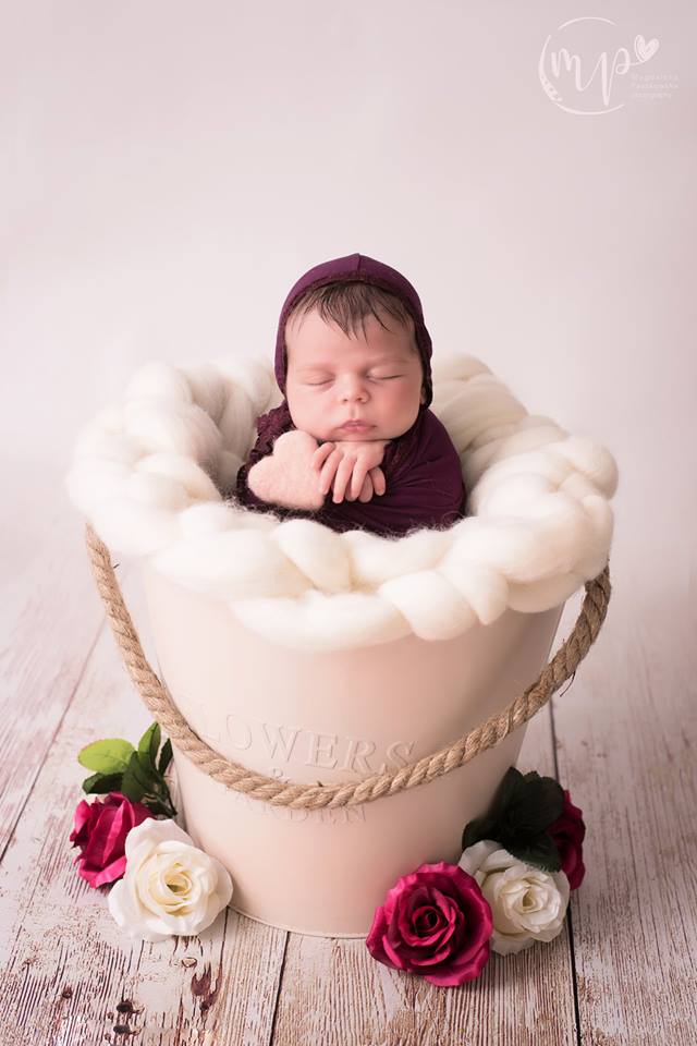 Chunky wool nest used as a soft textured filler inside a metal bucket for newborn photography