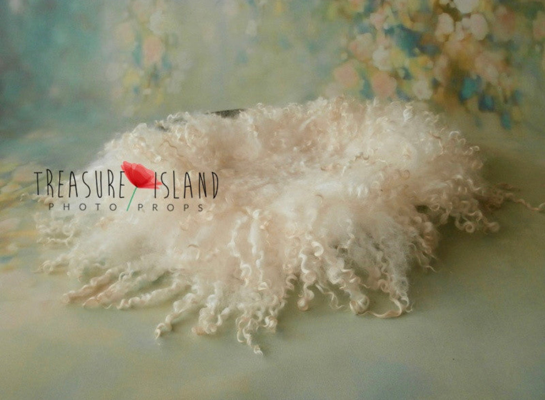 Side view of the hand-felted Pearl White wool blanket showing its natural curly sheep locks
