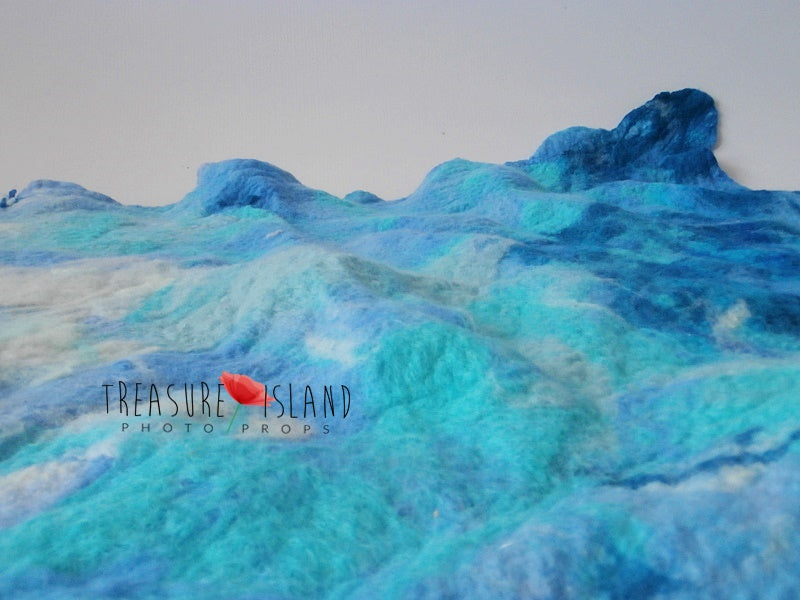 Sculptural hand-felted wool texture inspired by rolling turquoise and blue ocean waves