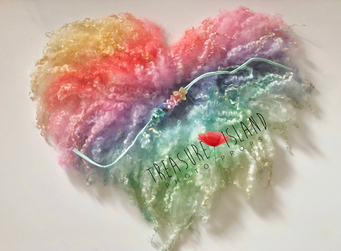 Hand-felted heart-shaped curly wool blanket in intense rainbow colours for newborn photography