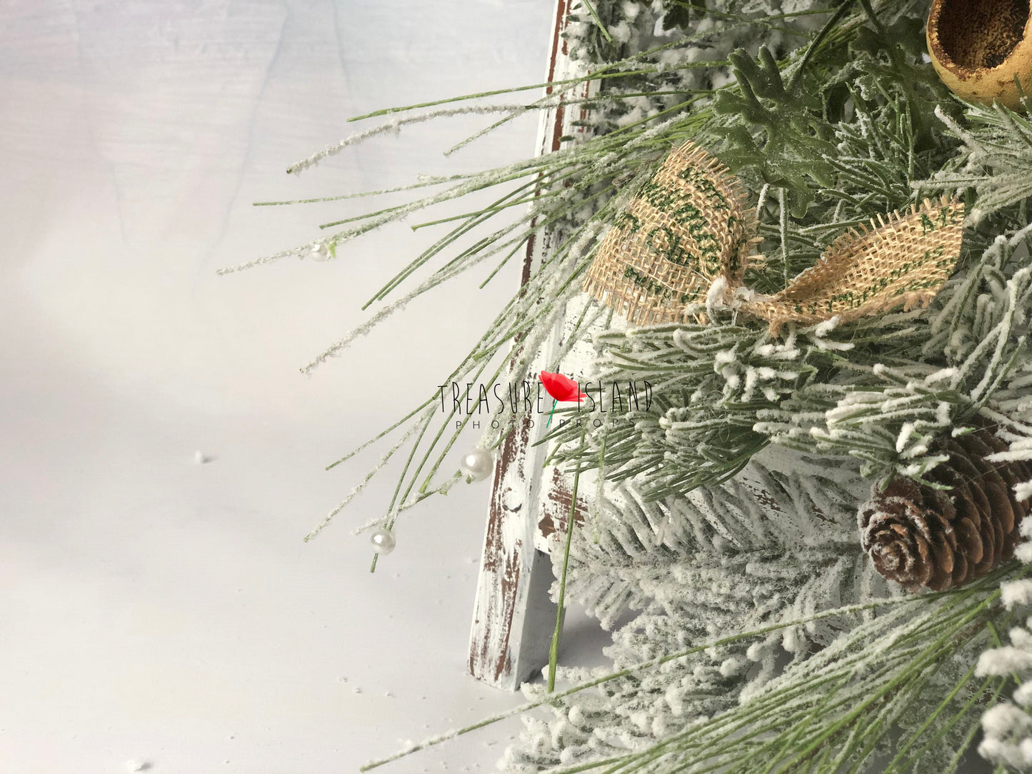 Snowy Christmas garland with frosted greenery, pinecone and rustic burlap bow details